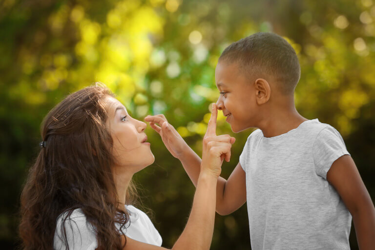 pic of smiling mom and young son touch one another's noses