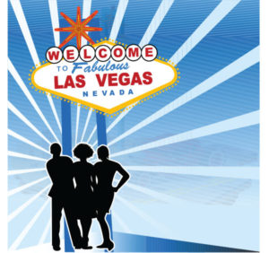 A group of people posing in front of the Las Vegas sign, smiling and enjoying the bright lights of the city.